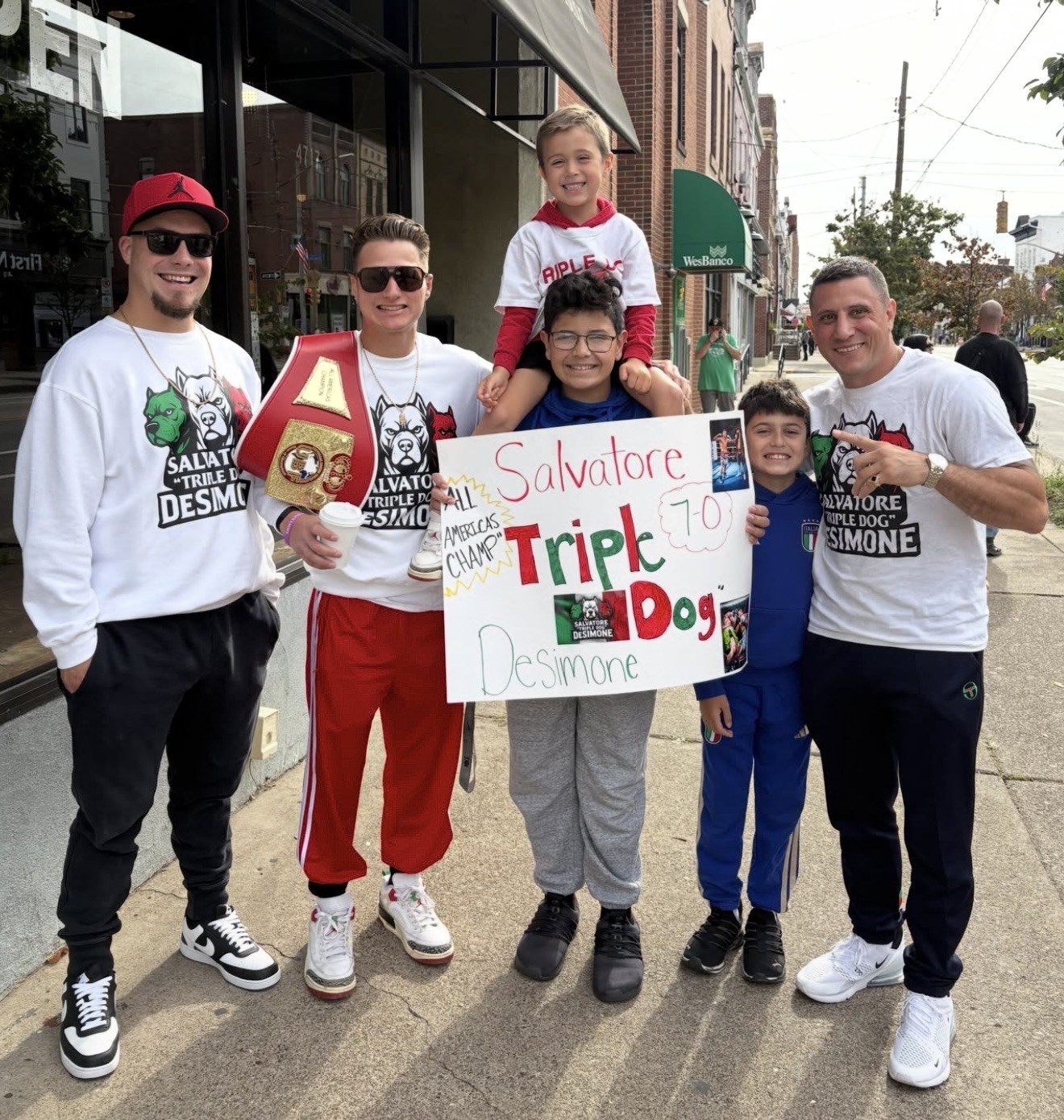 Salvatore DeSimone with his UBF championship belt and supporters holding a handmade tribute in Bloomfield.